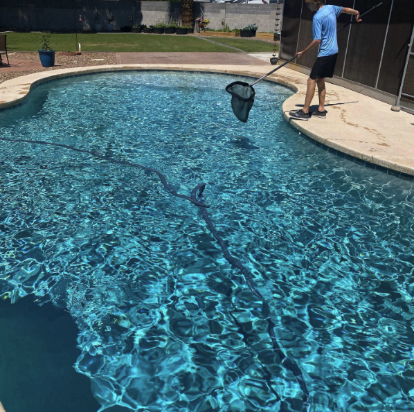 BIG Family Pools Route Manager skimming a residential pool
